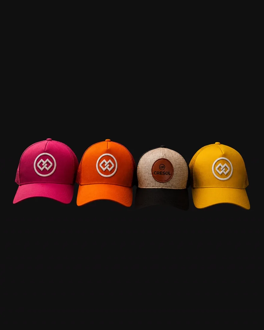 Bonés iguais em rosa, laranja, bege e amarelo mostrando as opções de cor